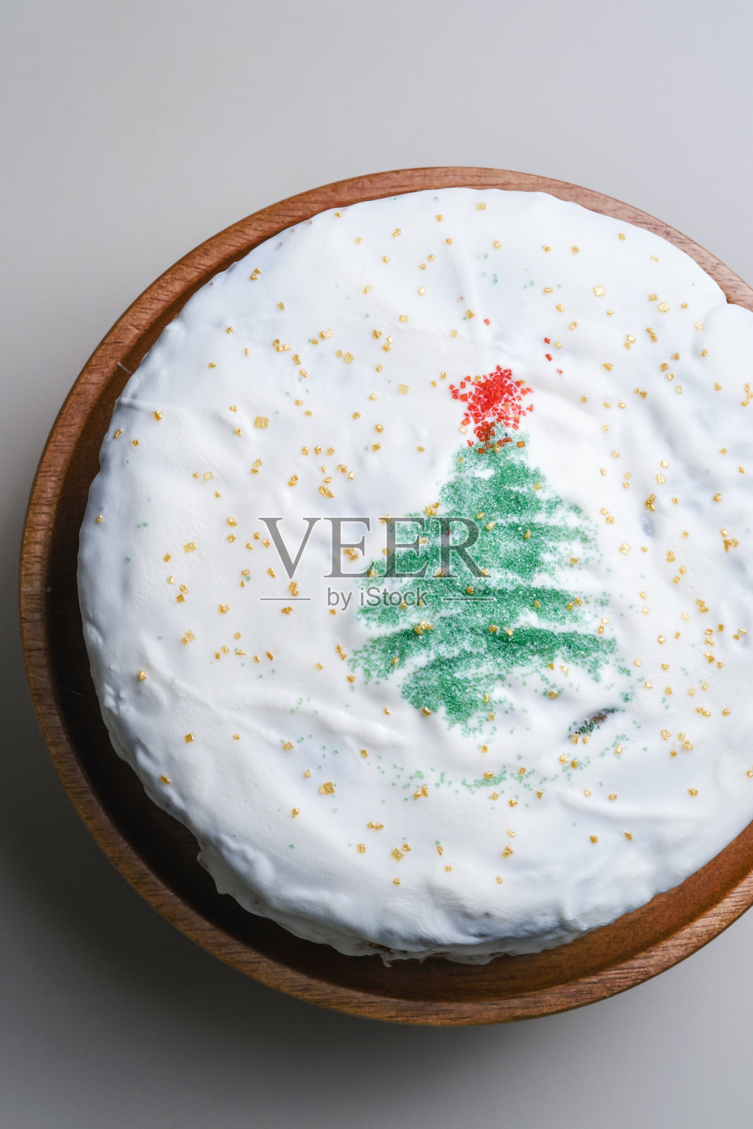 在松饼蛋糕的白色釉上用糖做成星星的圣诞树。照片摄影图片