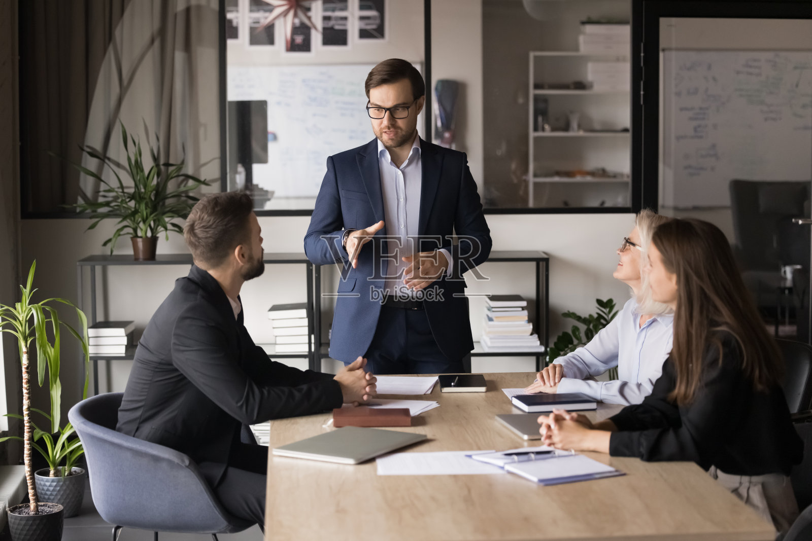 严肃的年轻商业领袖正在和经理们开会照片摄影图片