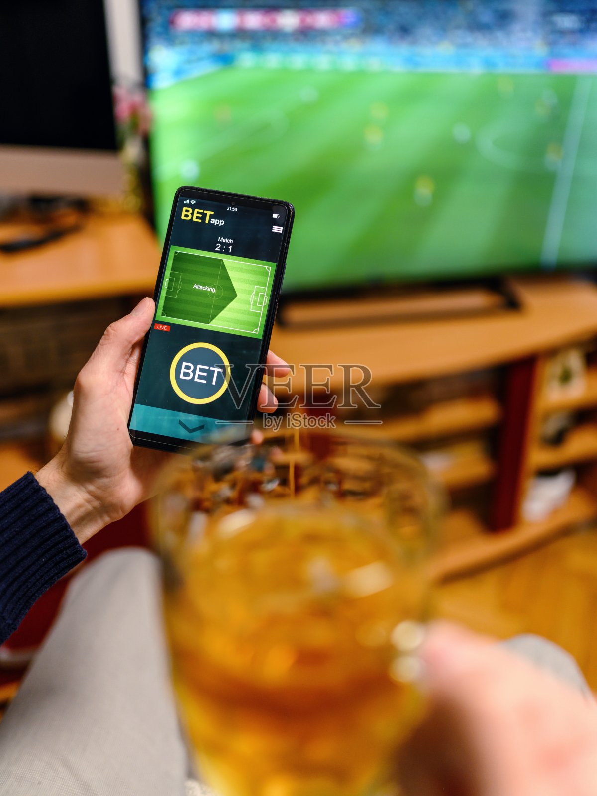 年轻人用智能手机进行体育博彩。照片摄影图片