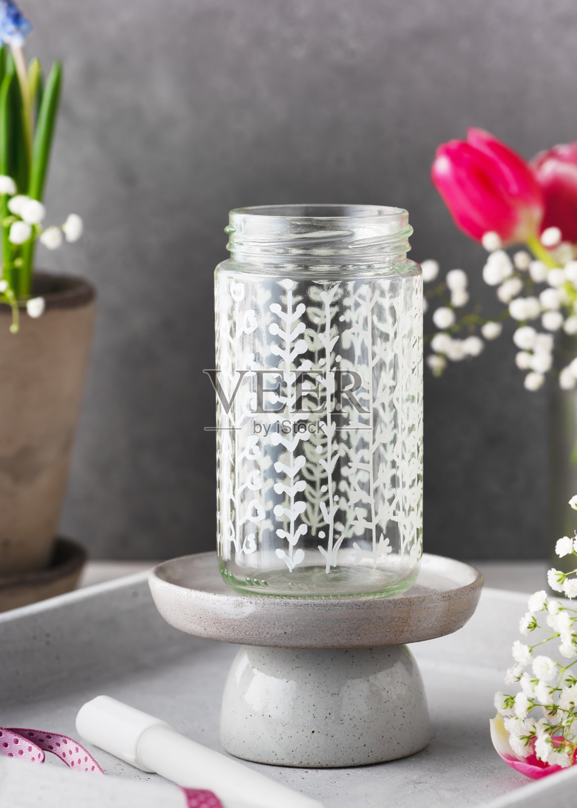 美丽的手绘玻璃花瓶，有不同的植物图案。用回收玻璃制作的手工礼物或装饰。照片摄影图片