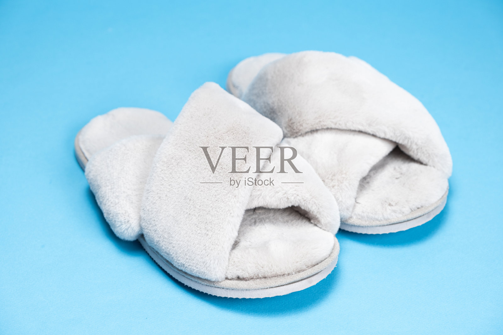 蓝色背景的现代时尚毛绒灰色拖鞋照片摄影图片