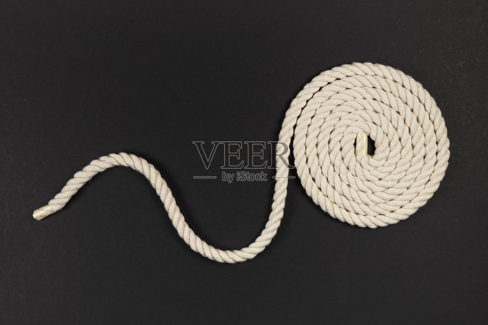 黑色背景上盘绕的绳子照片摄影图片