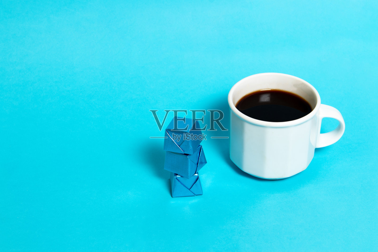 蓝色包装的巧克力糖和一杯咖啡照片摄影图片