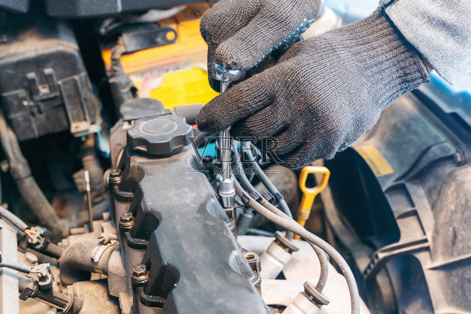 机械师的手拧下内燃机的气门盖，更换垫圈照片摄影图片