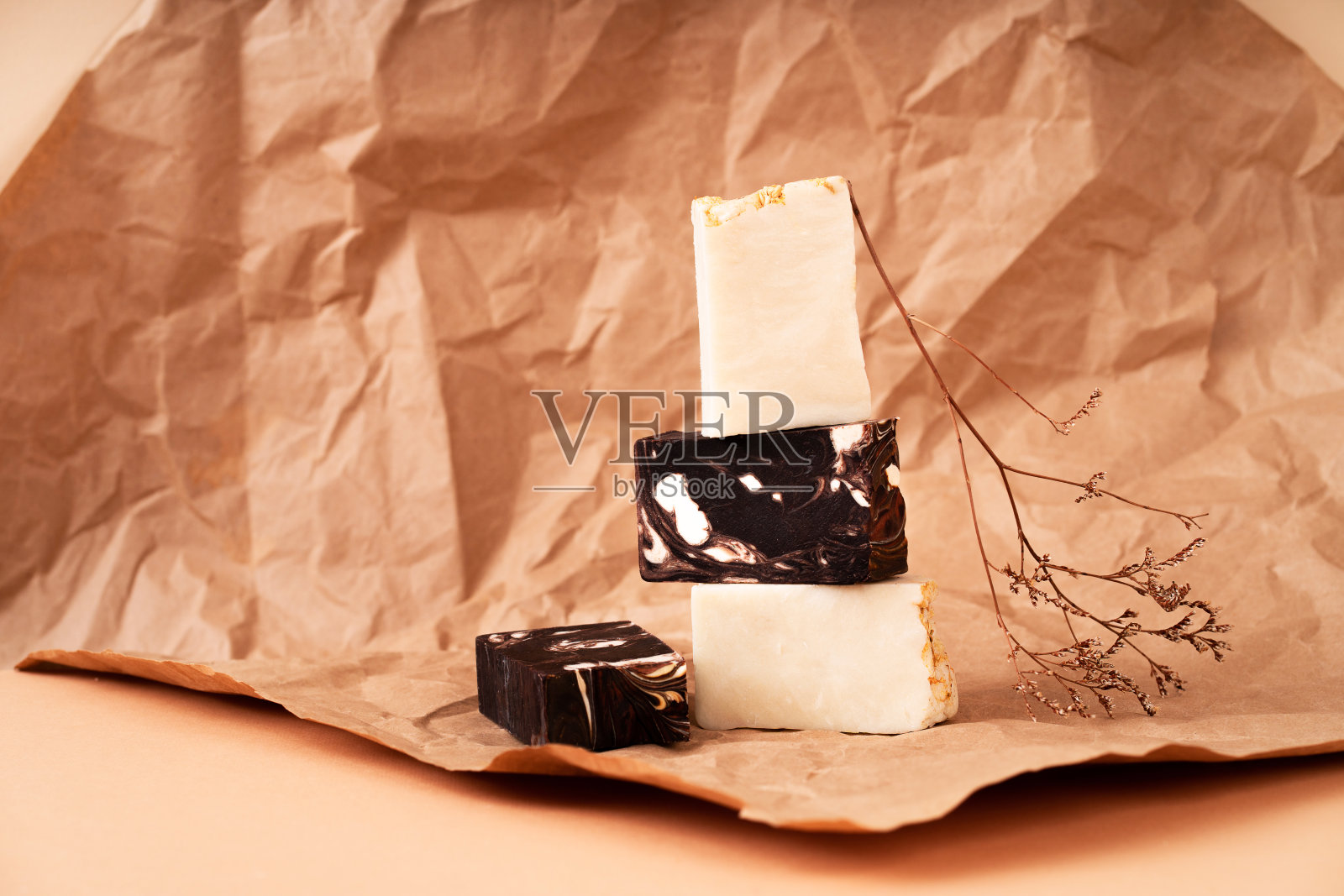 不同大小和颜色的天然手工肥皂。桃色背景材料天然，木质，干花。化妆品底座，用于产品推广照片摄影图片