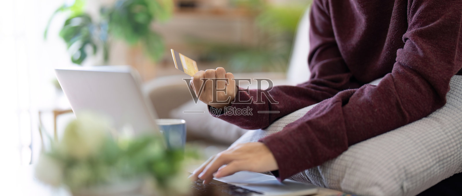 女人正在网上购物。女孩正在家里用笔记本电脑和信用卡购物照片摄影图片