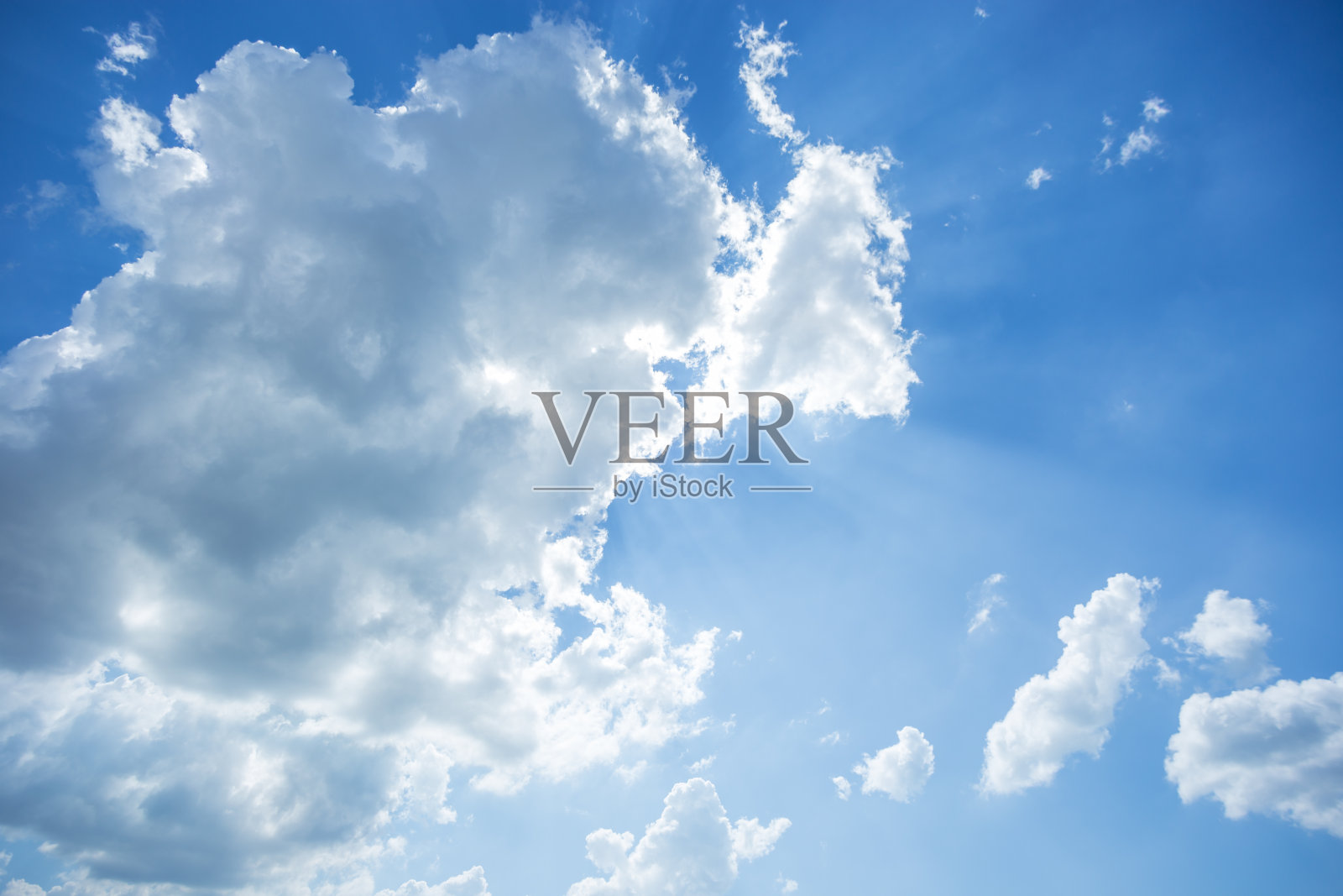 太阳在蓝色的天空背景与蓬松的白云照片摄影图片