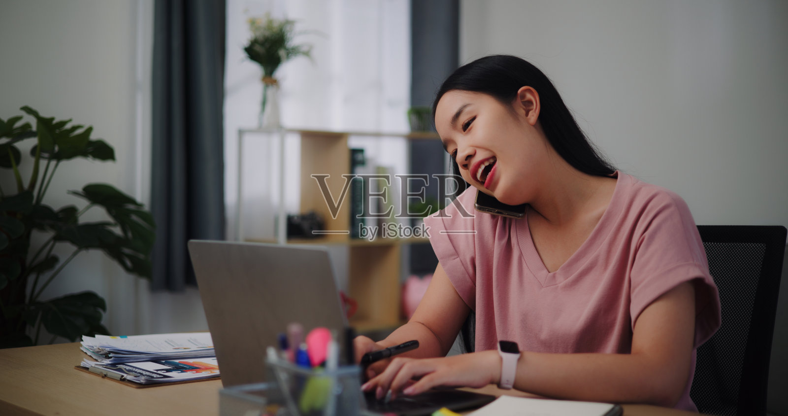 年轻女子在家里用笔记本电脑工作。照片摄影图片