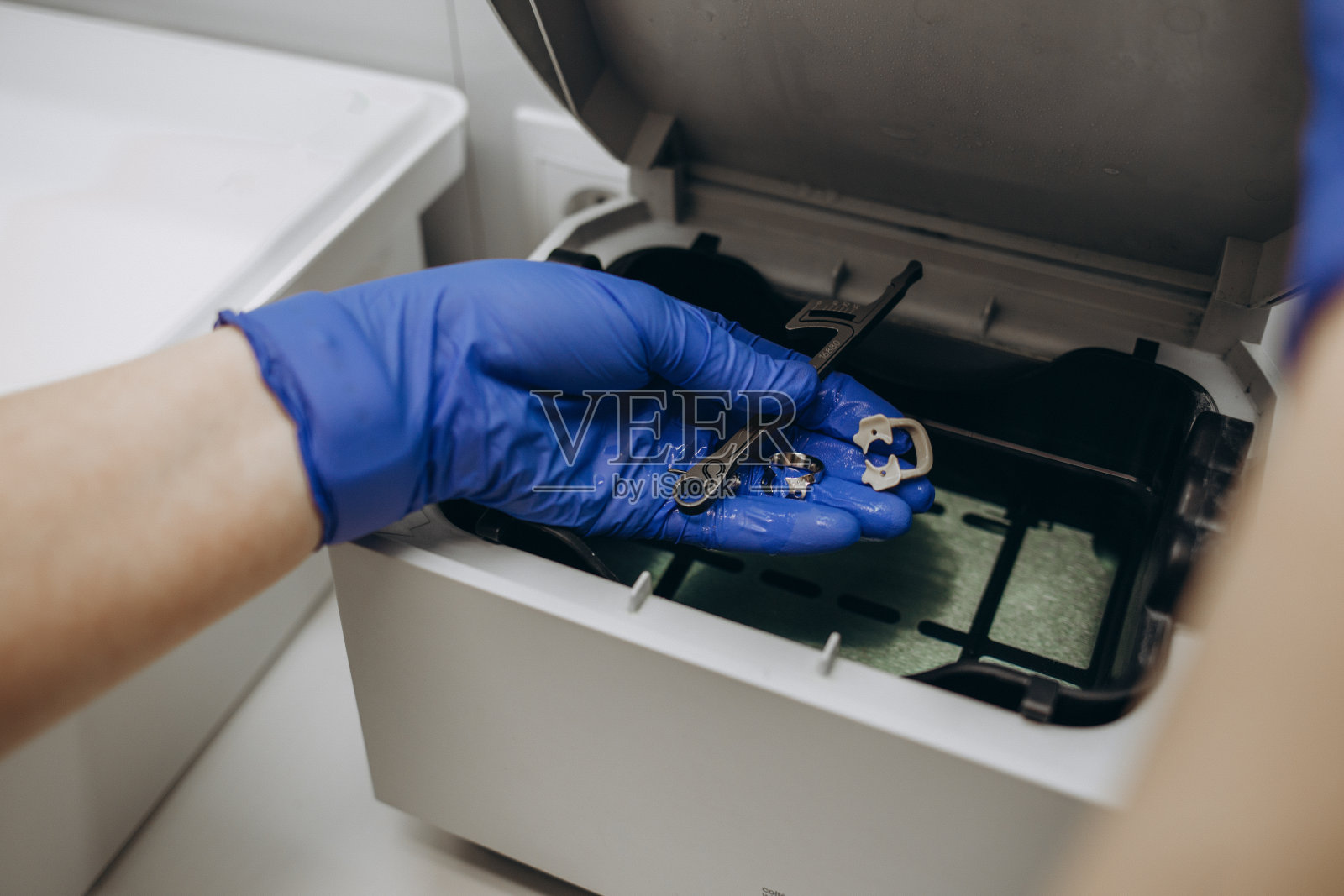 医用高压灭菌器用于外科手术消毒的地方，近距离戴手套的手照片摄影图片