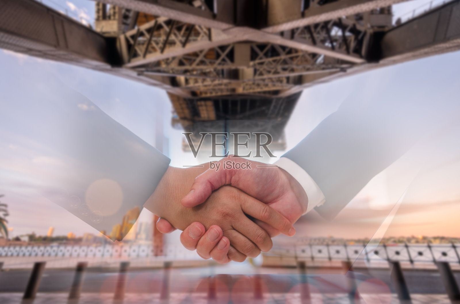 一个男人和女人或商务人士与合作伙伴握手打招呼或处理业务合资企业模糊桥和城市背景照片摄影图片