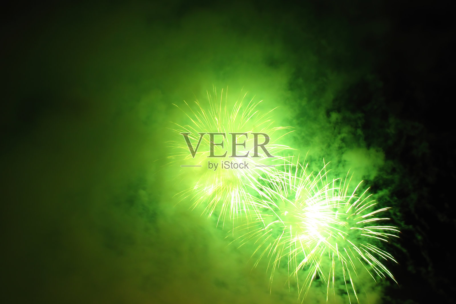 绿色明亮的烟花在漆黑的夜空中闪烁照片摄影图片