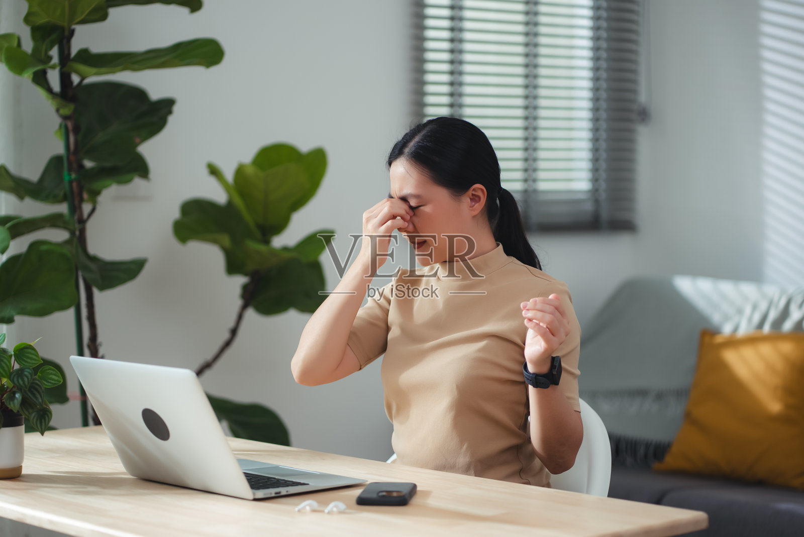 一名亚洲女性在家办公时眼睛疼痛。照片摄影图片