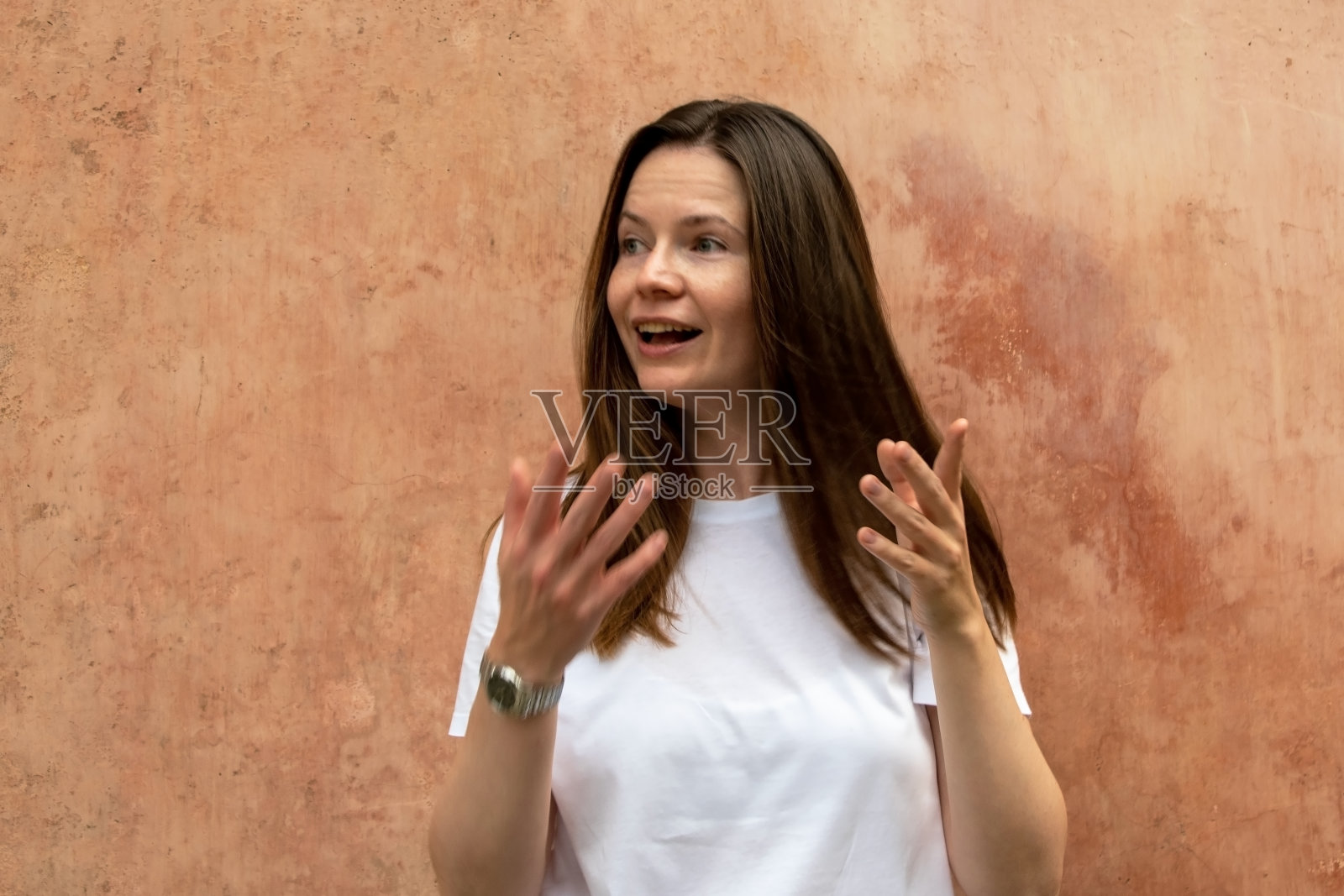 一个漂亮的年轻女人的肖像，棕色的长发，白色的t恤。照片摄影图片