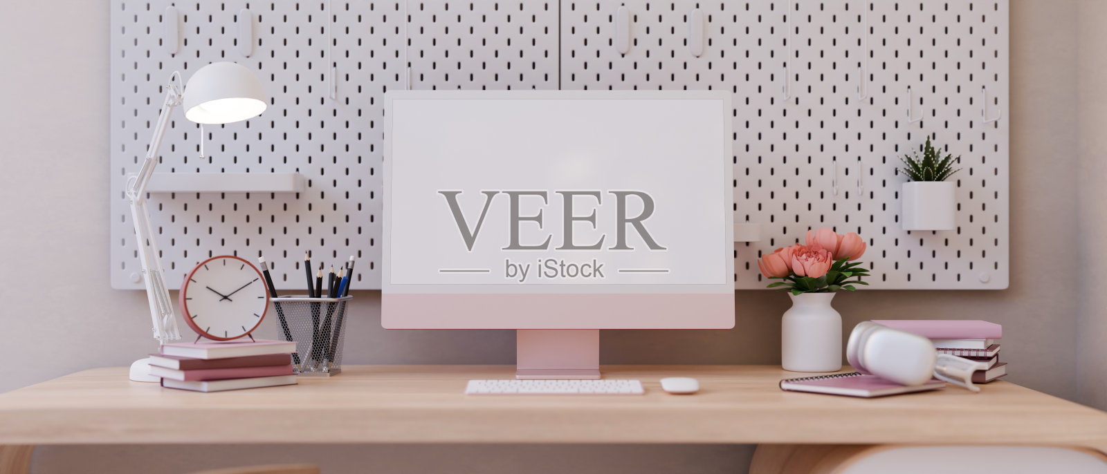 粉红色女性办公桌的正面图像，粉红色的电脑模型和配件。照片摄影图片