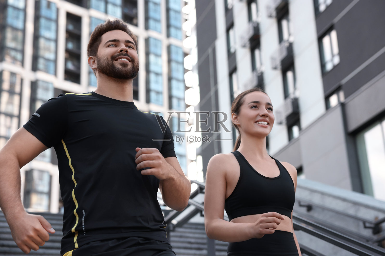 健康的生活方式。幸福的情侣在户外台阶上跑步，低角度观看照片摄影图片