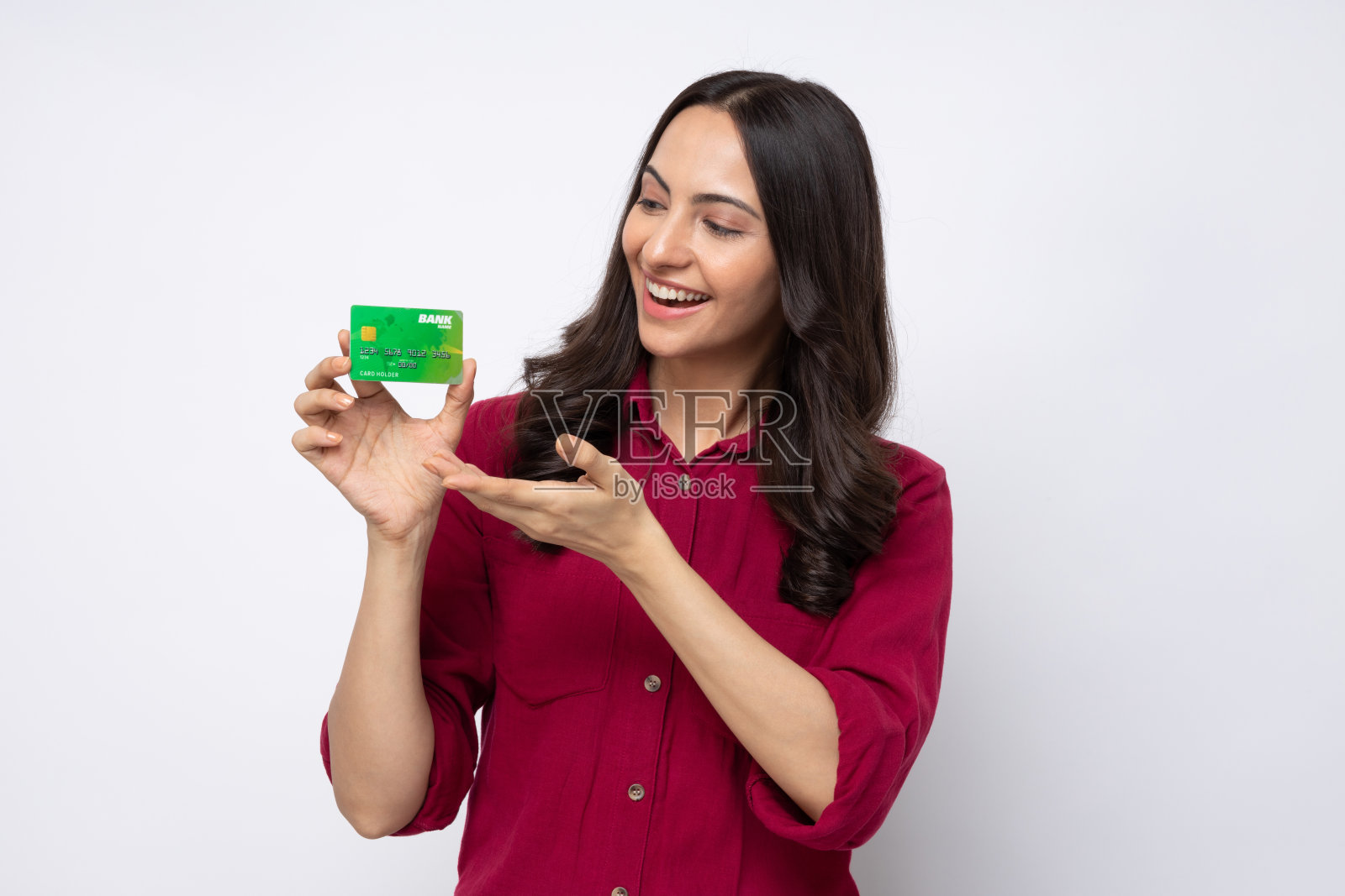 开朗的女孩穿着衬衫的肖像拿着塑料银行卡购物付款孤立在白色背景股票照片照片摄影图片