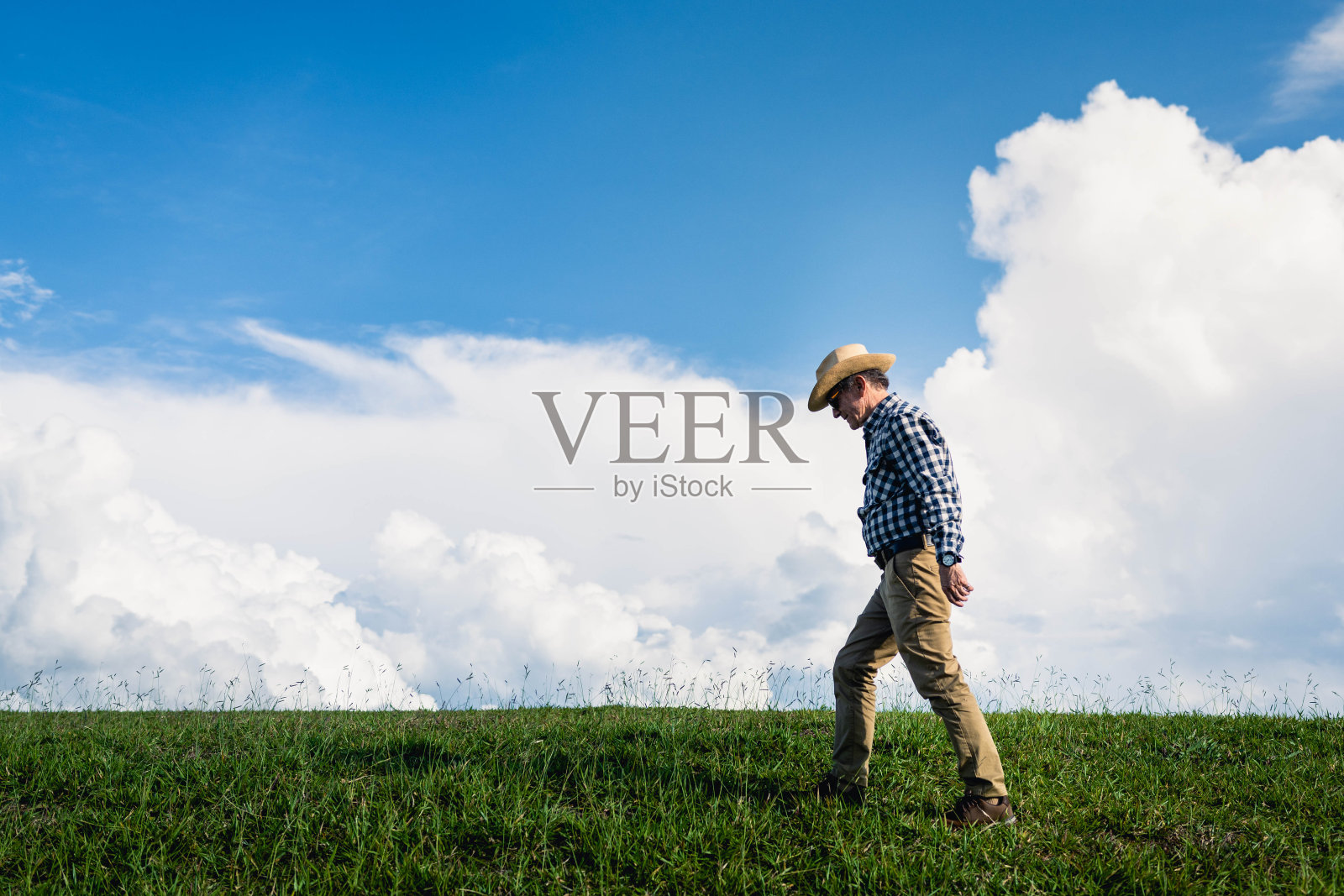 一位老人走过一片草地照片摄影图片