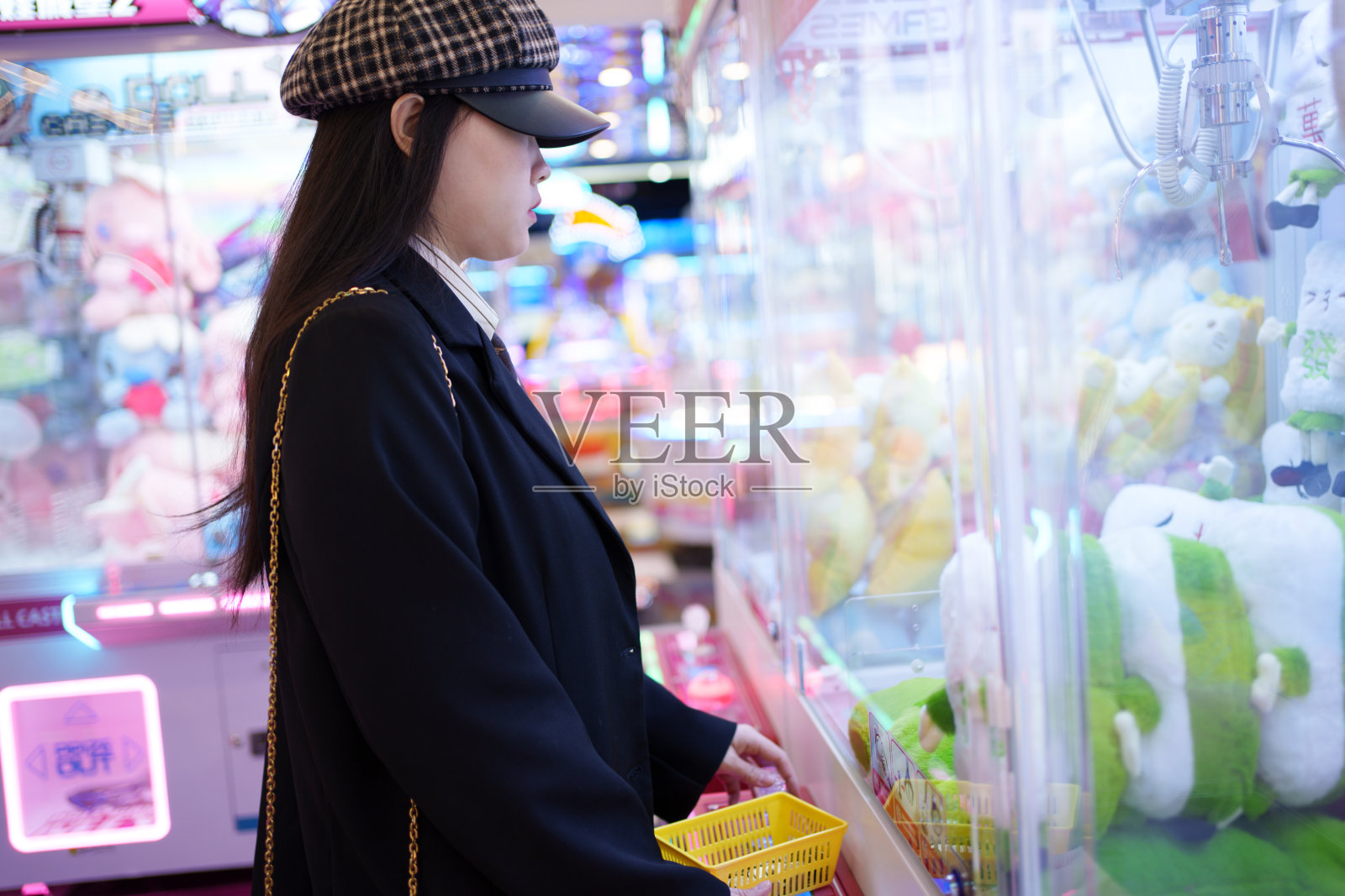 年轻女子在玩夹娃娃照片摄影图片