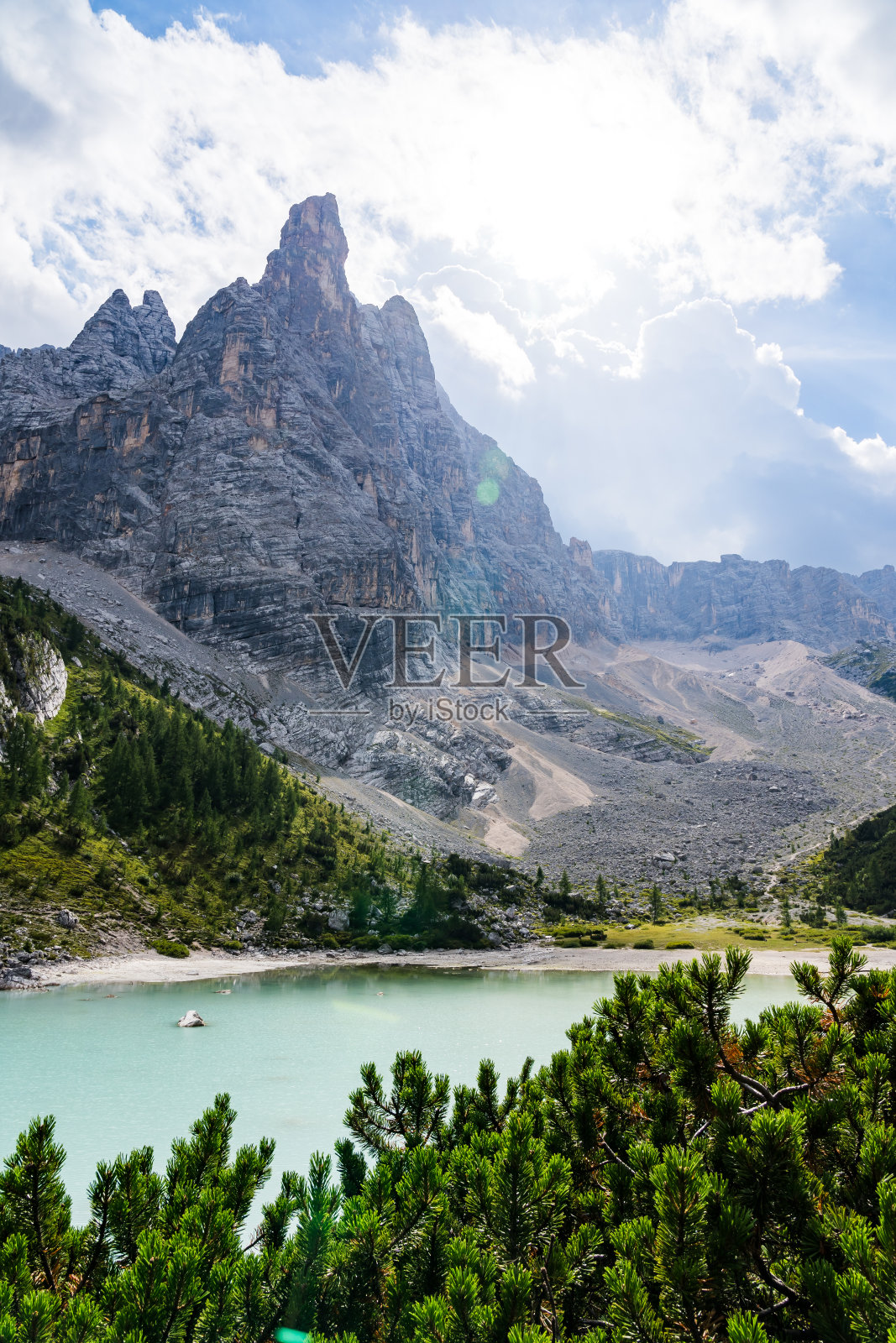在一个阳光明媚的日子里，白云石山脉的索拉皮斯湖，前景是绿松石湖和松树，背景是一座巨大的山峰照片摄影图片