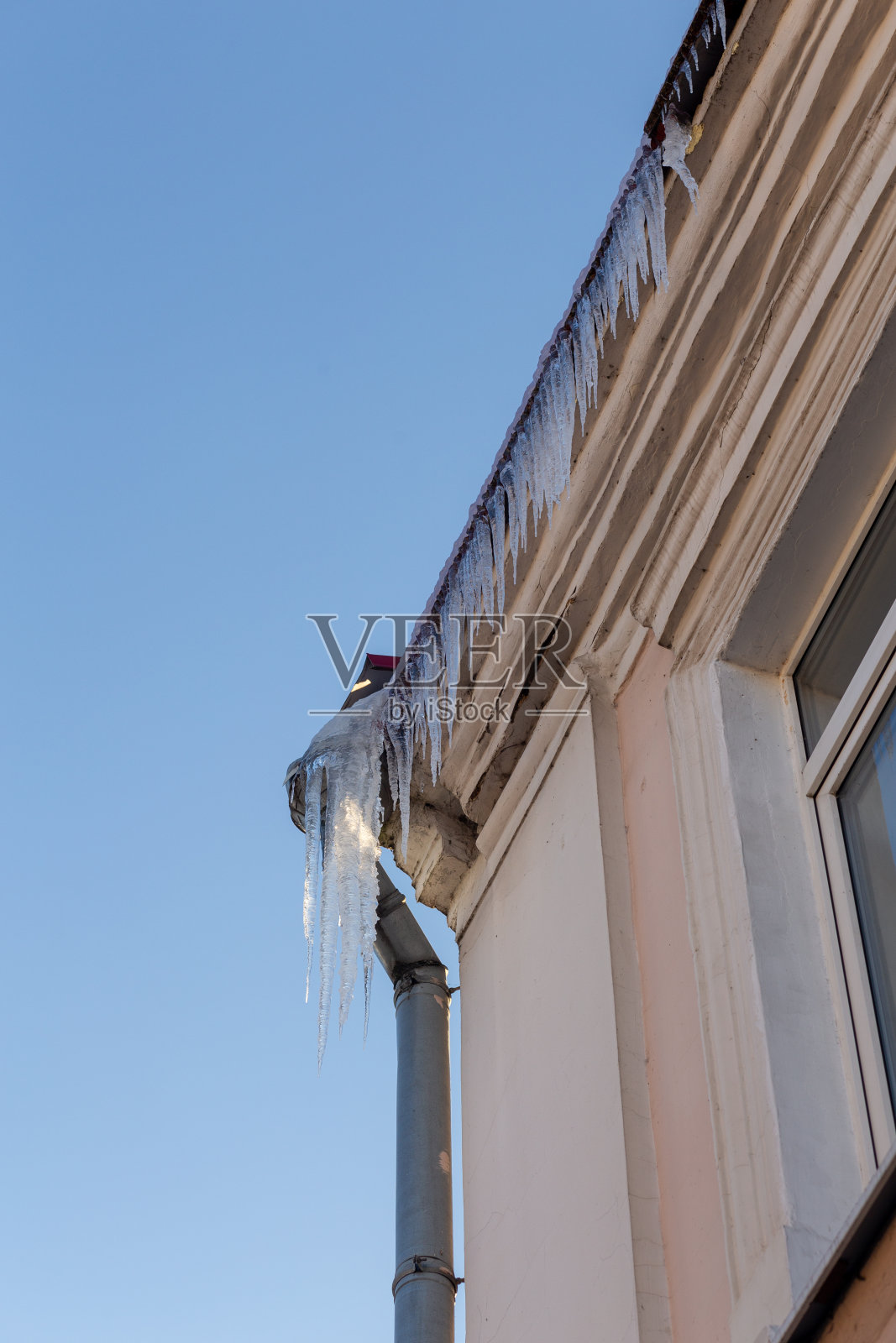 联排别墅屋顶上的大冰柱照片摄影图片