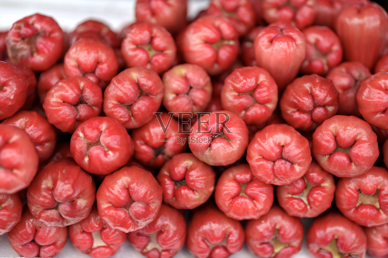 一堆本土的红玫瑰苹果展示了这些苹果充满活力和独特的外观，可供消费或出售。照片摄影图片