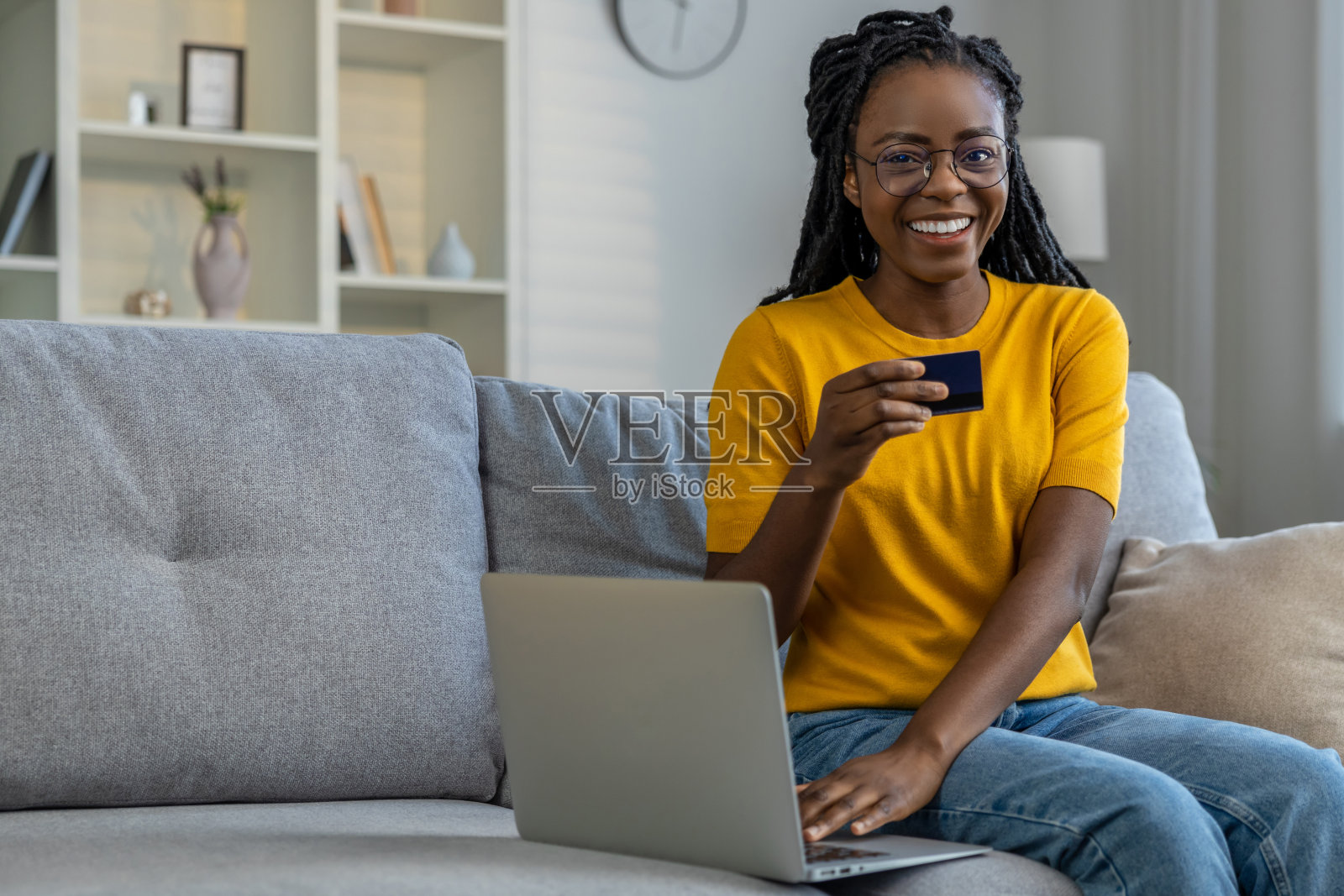 年轻的黑皮肤女子在网上支付时看起来很满足照片摄影图片