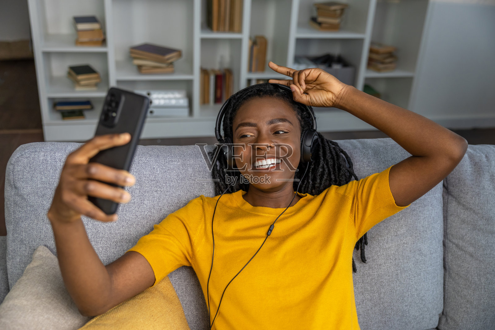 穿着黄色t恤的可爱微笑的年轻女子看起来很开心照片摄影图片