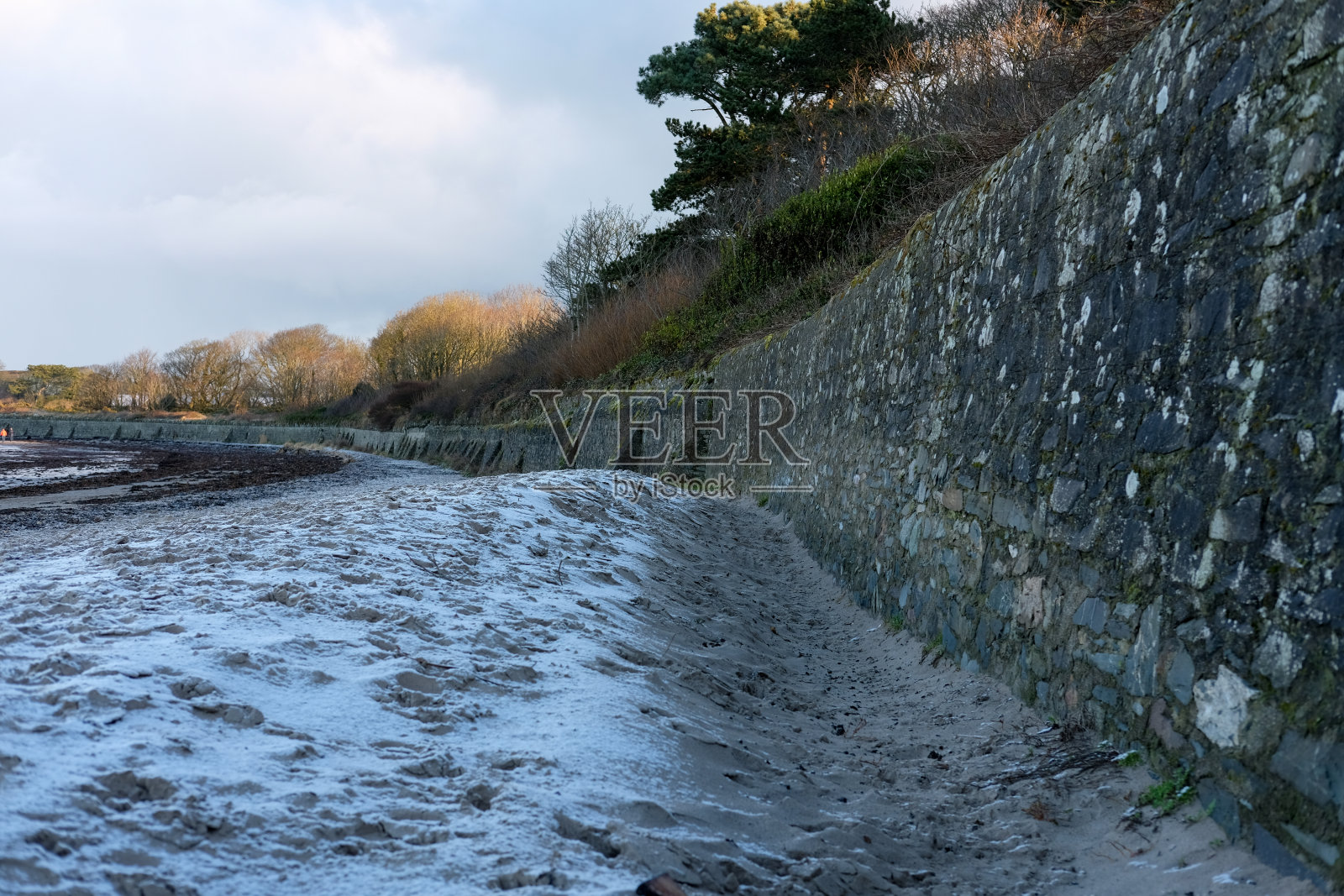 冬季寒流期间，雪沉淀在沙滩上照片摄影图片