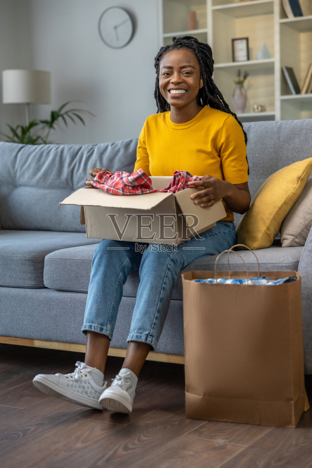 年轻女子打开网上商店的快递，看起来很满足照片摄影图片