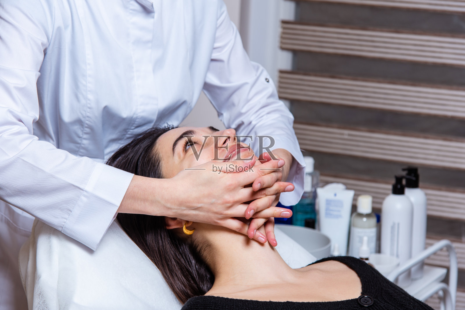 在水疗中心办公室进行面部和颈部的放松和提油按摩照片摄影图片