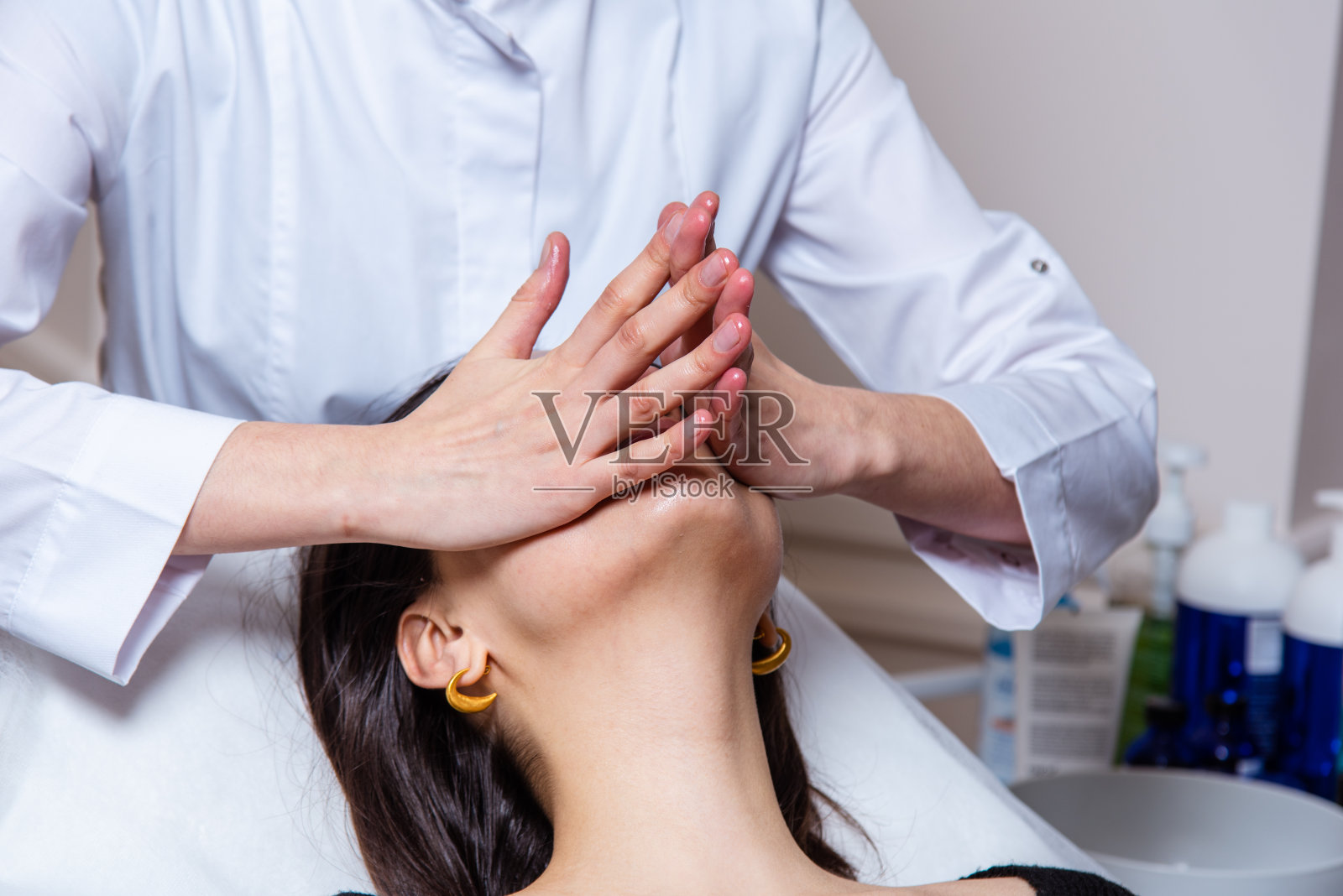 在水疗中心办公室进行面部和颈部的放松和提油按摩照片摄影图片