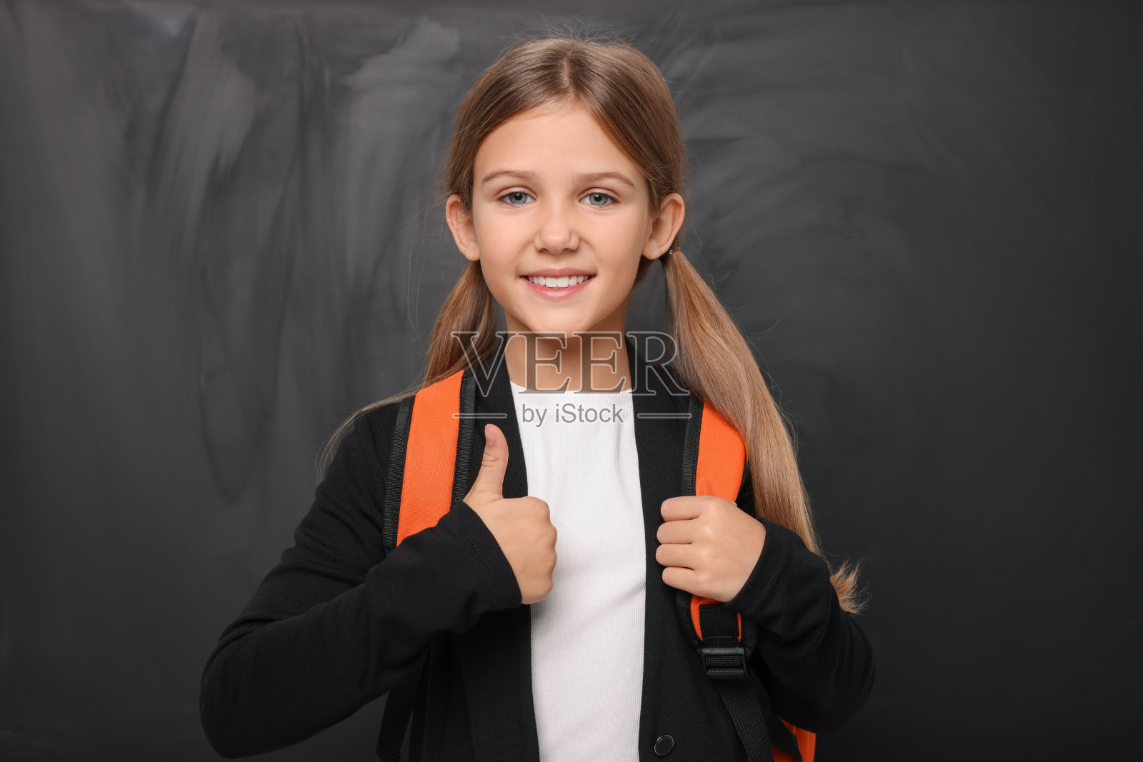 微笑的女学生在黑板旁边竖起大拇指照片摄影图片