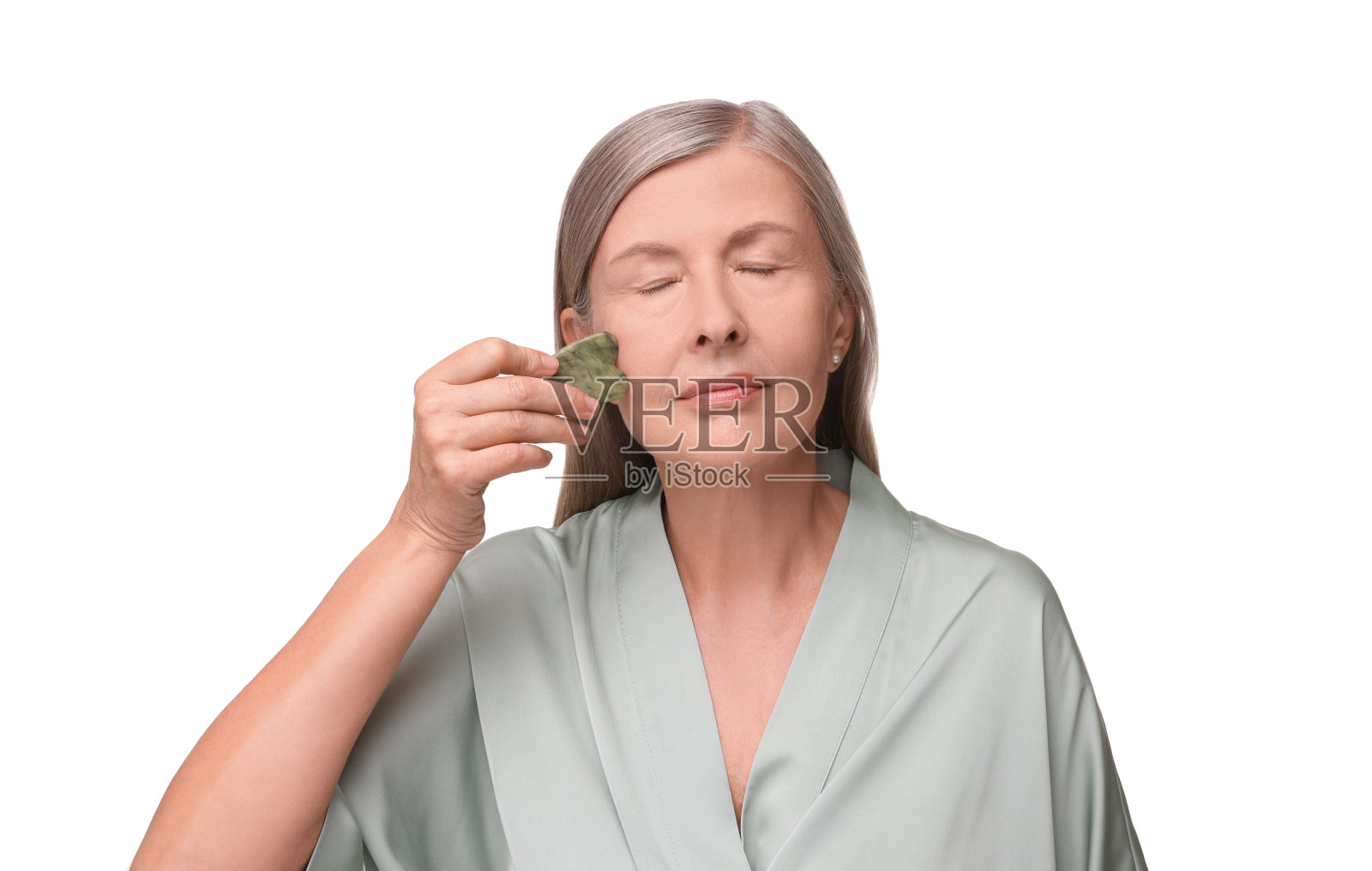 女人用玉刨沙工具按摩她的脸，孤立在白色上照片摄影图片