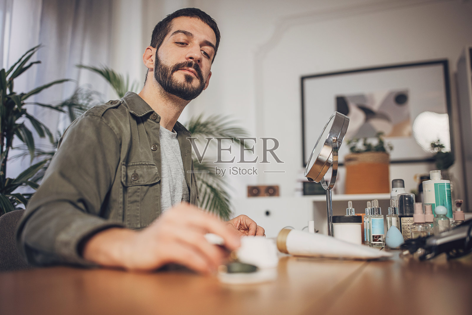 男子在家用玉辊按摩脸部，做面部护理照片摄影图片