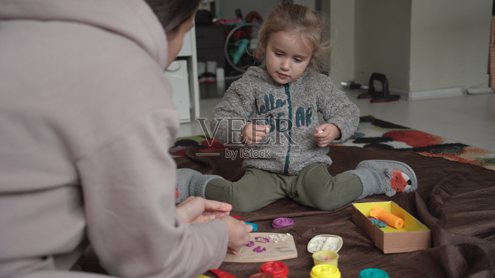 妈妈和孩子在家里玩橡皮泥。家庭时间。照片摄影图片