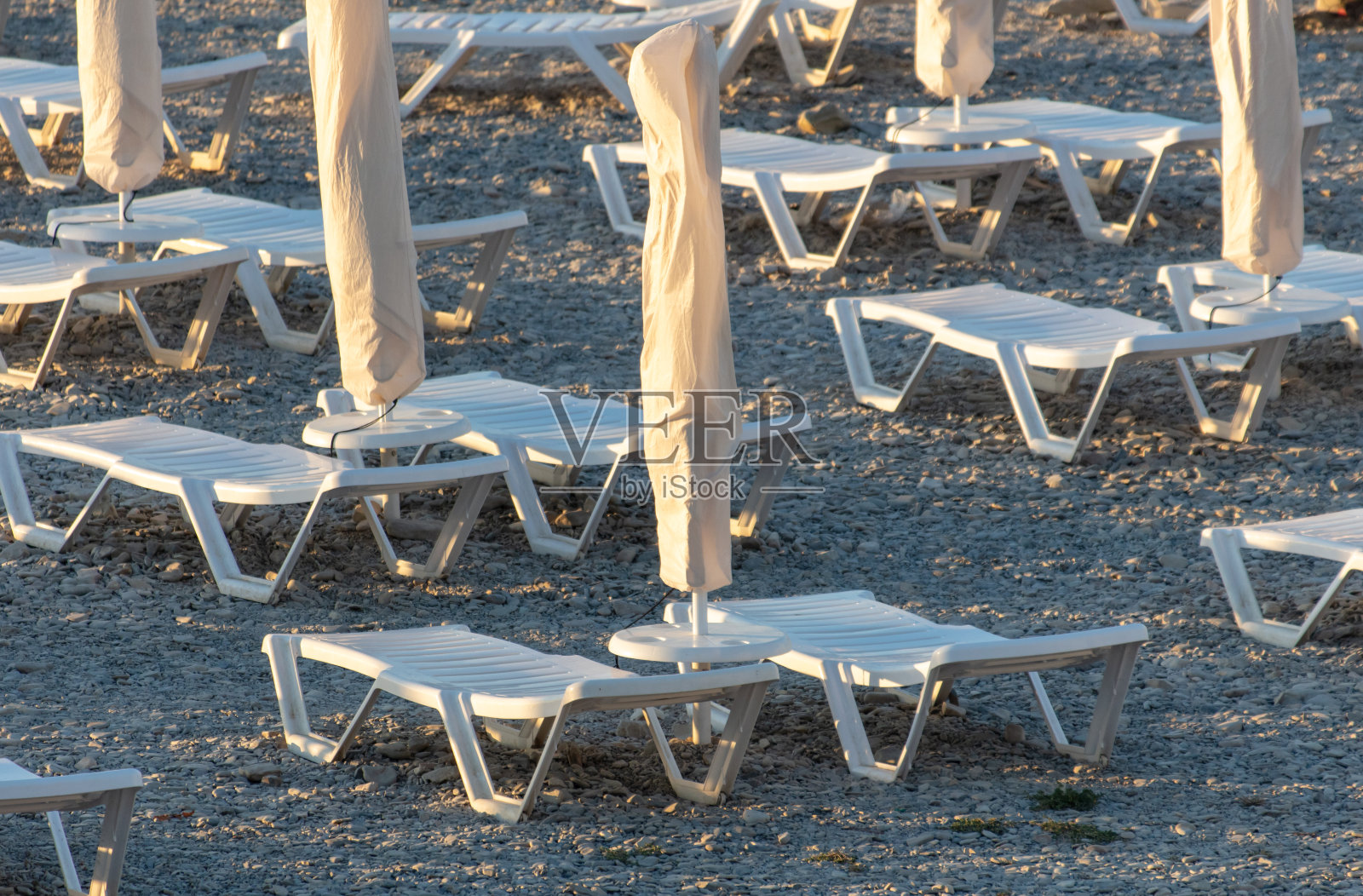 沙滩上晒日光浴的躺椅旁的遮阳伞照片摄影图片