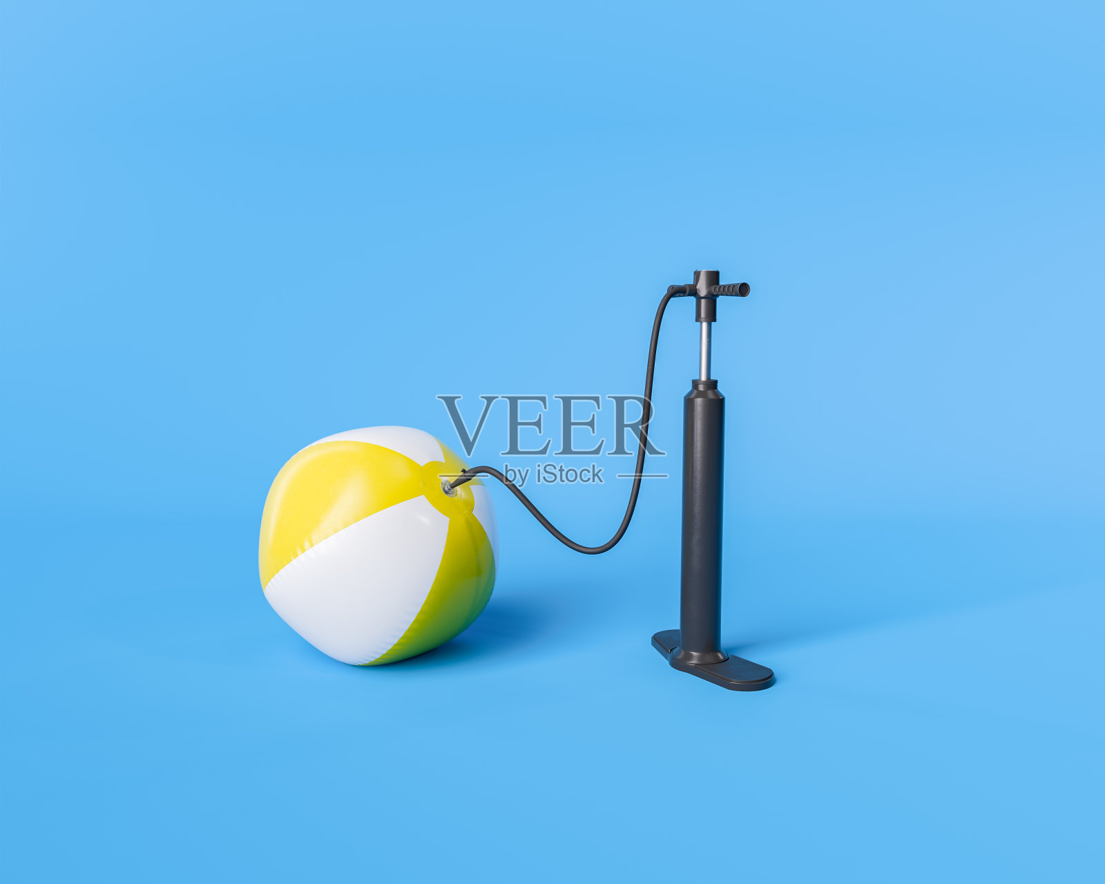 用打气筒给黄白相间的沙滩球充气照片摄影图片