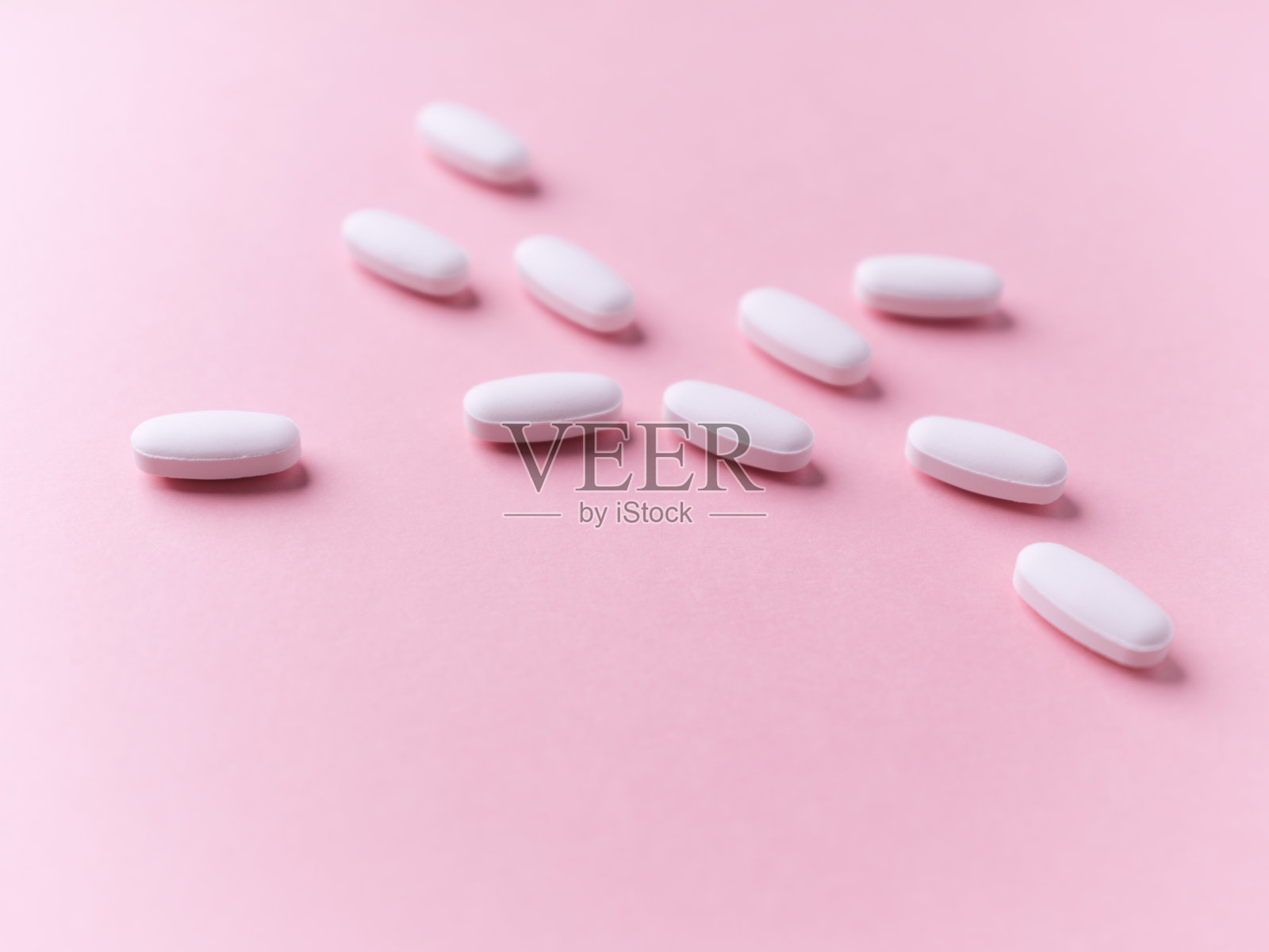 白色的药片在明亮的纸张背景上。软的焦点。关闭了。副本的空间。照片摄影图片