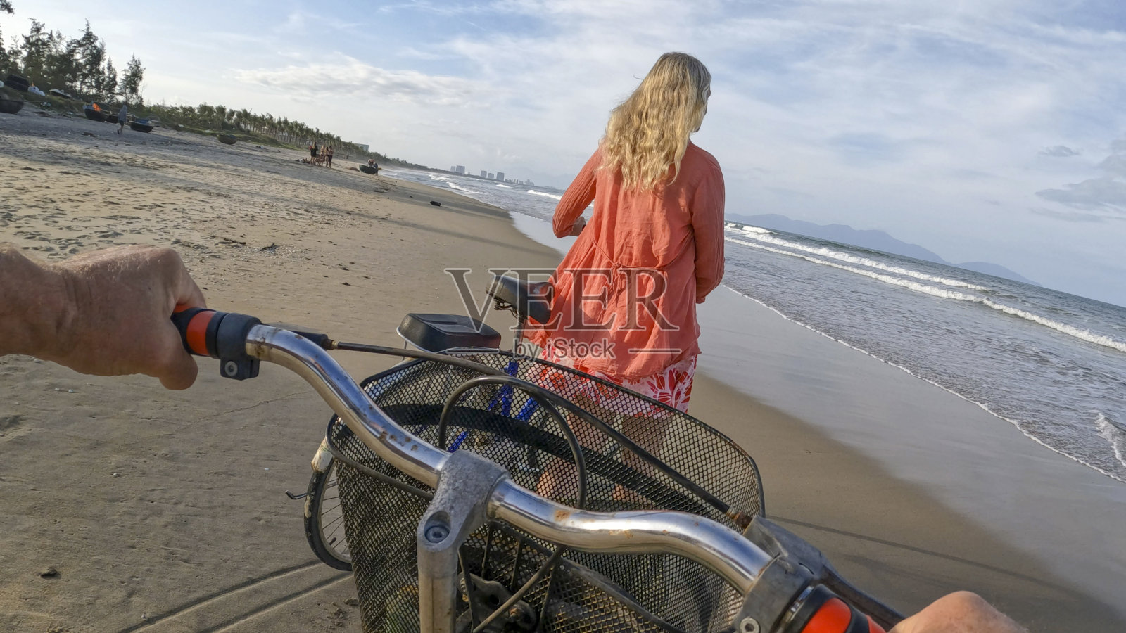 一对夫妇推着自行车在海滩上的个人视角照片摄影图片