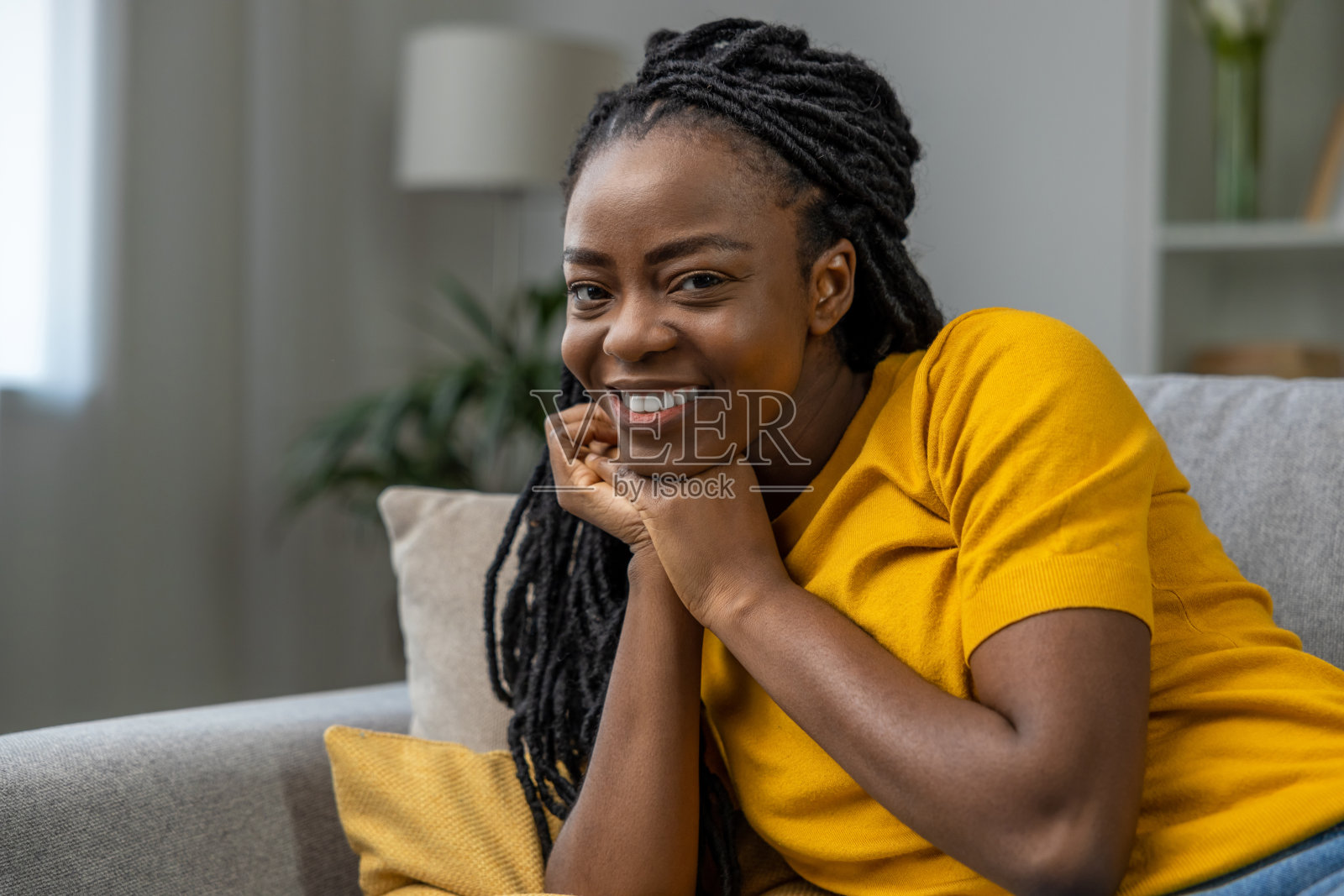 穿着黄色t恤的可爱非裔美国女人微笑着照片摄影图片