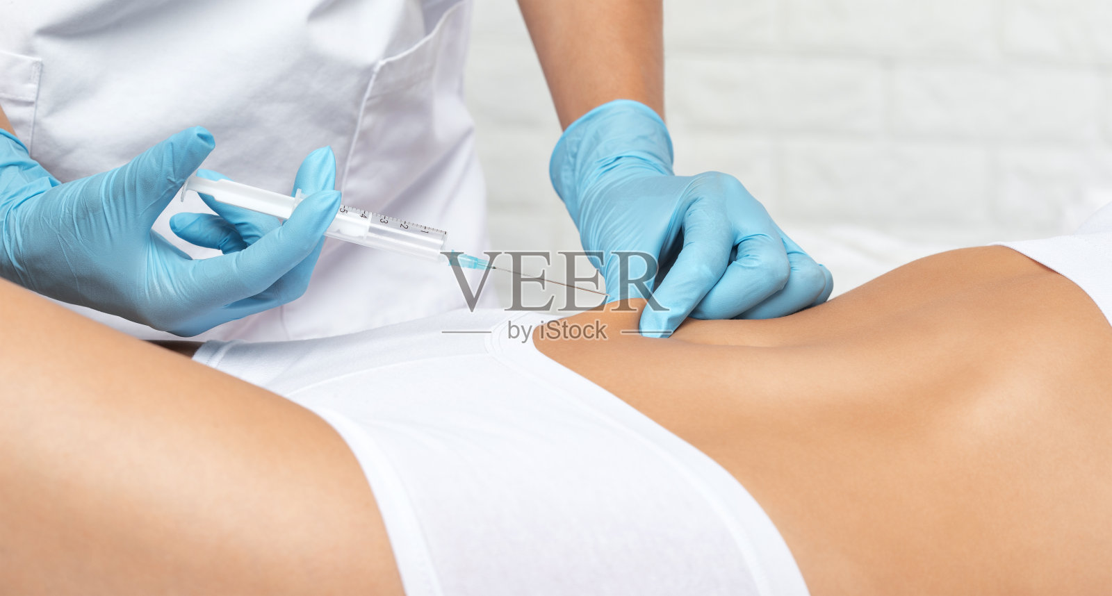 美容师为女性注射脂肪分解剂。美容院的女性审美美容。美容的概念。照片摄影图片