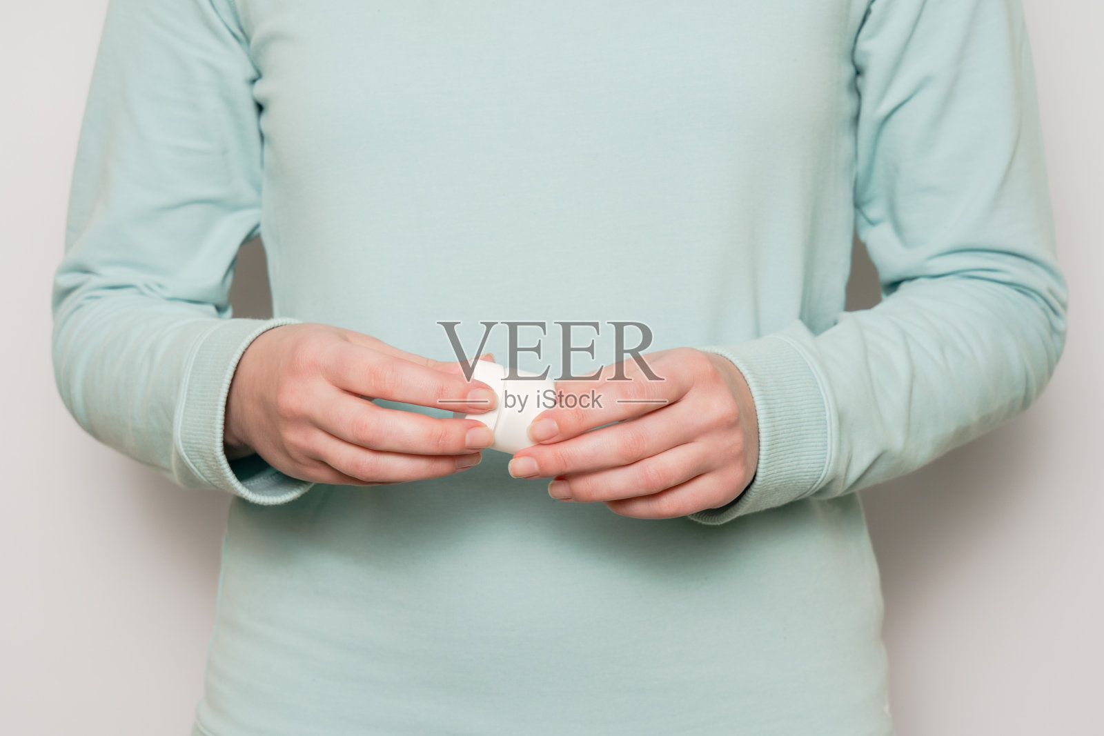 女人手里的塑料瓶(容器)。美容产品。照片摄影图片