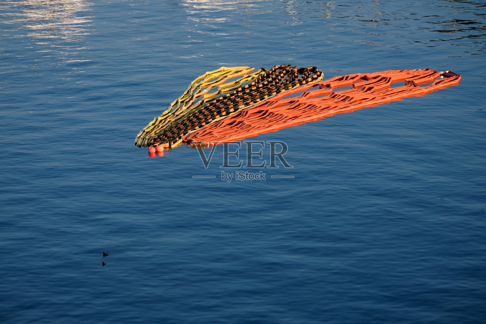 盘绕和折叠的标志屏障漂浮在海湾上照片摄影图片