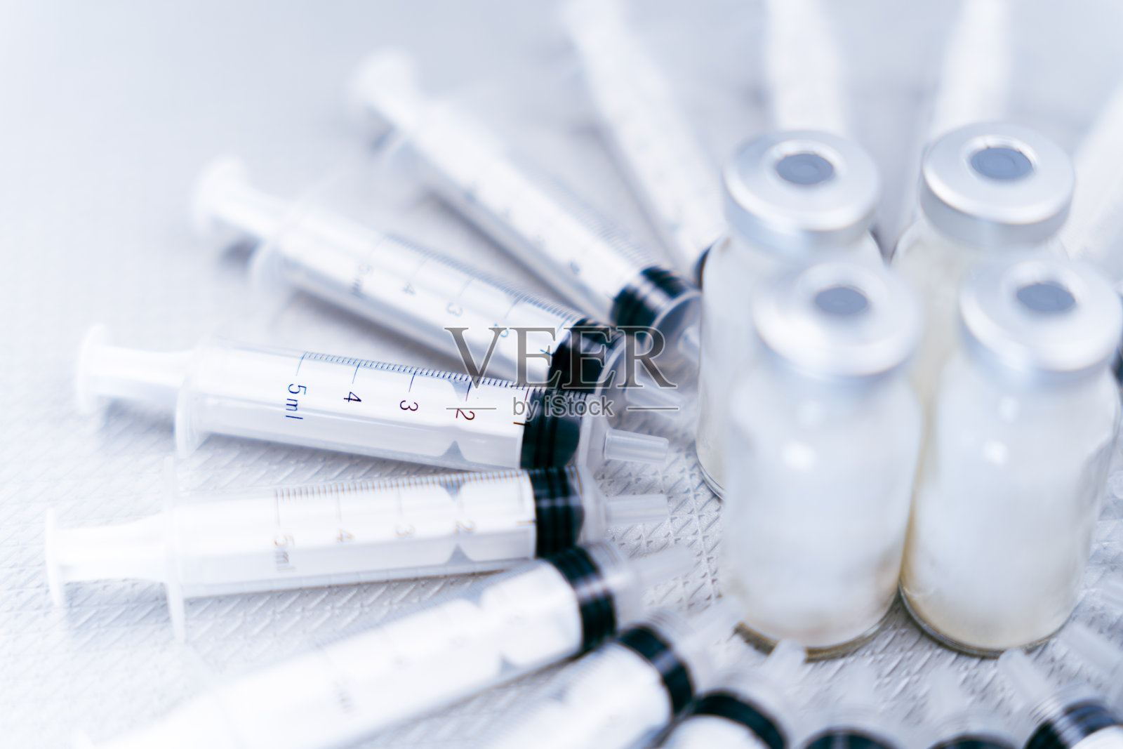 用新生产的医疗产品制成的组合物，在诊所和医院分发，形成一圈注射器，中心是小抗生素瓶照片摄影图片