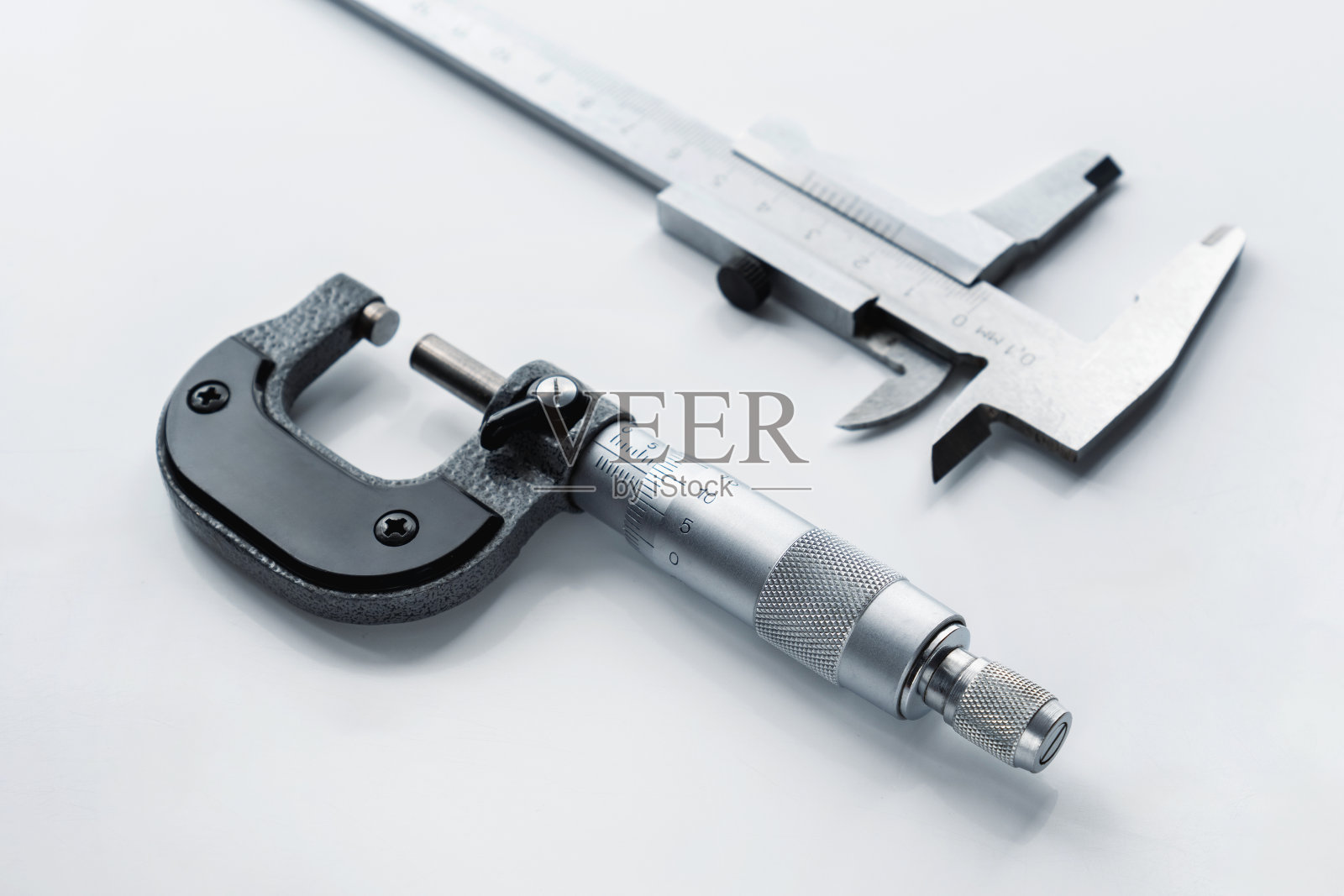 机械千分尺和卡尺在浅色背景上的特写。照片摄影图片