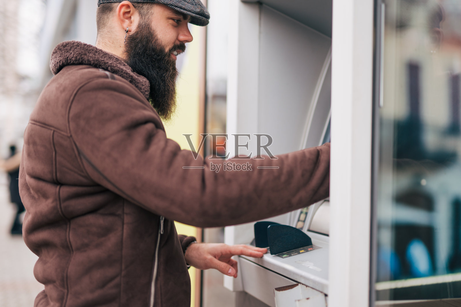 一名男子使用街头自动取款机取钱照片摄影图片