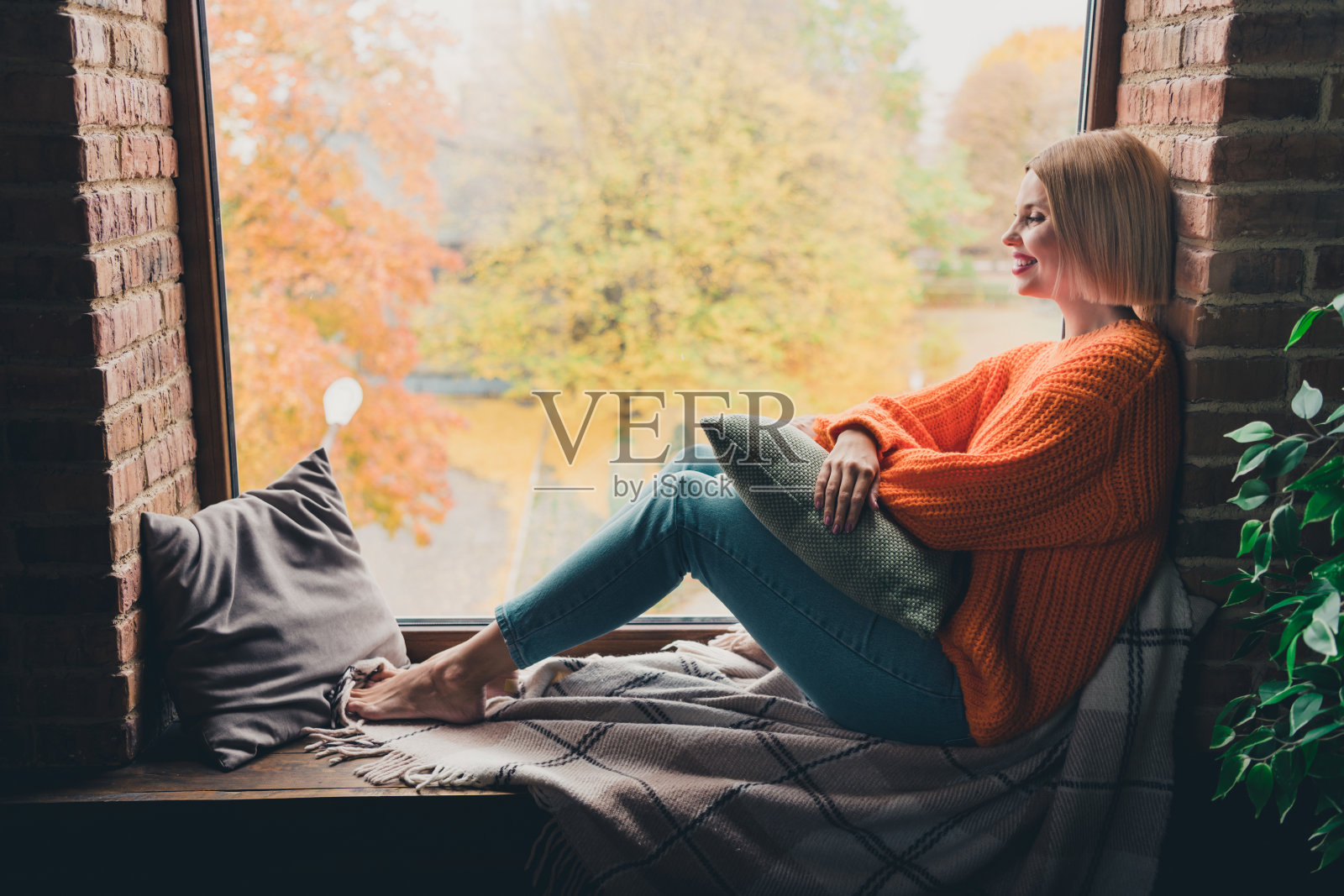 开朗华丽女士的全身侧面肖像光着脚坐在窗台上看自然想象幻想公寓里面照片摄影图片