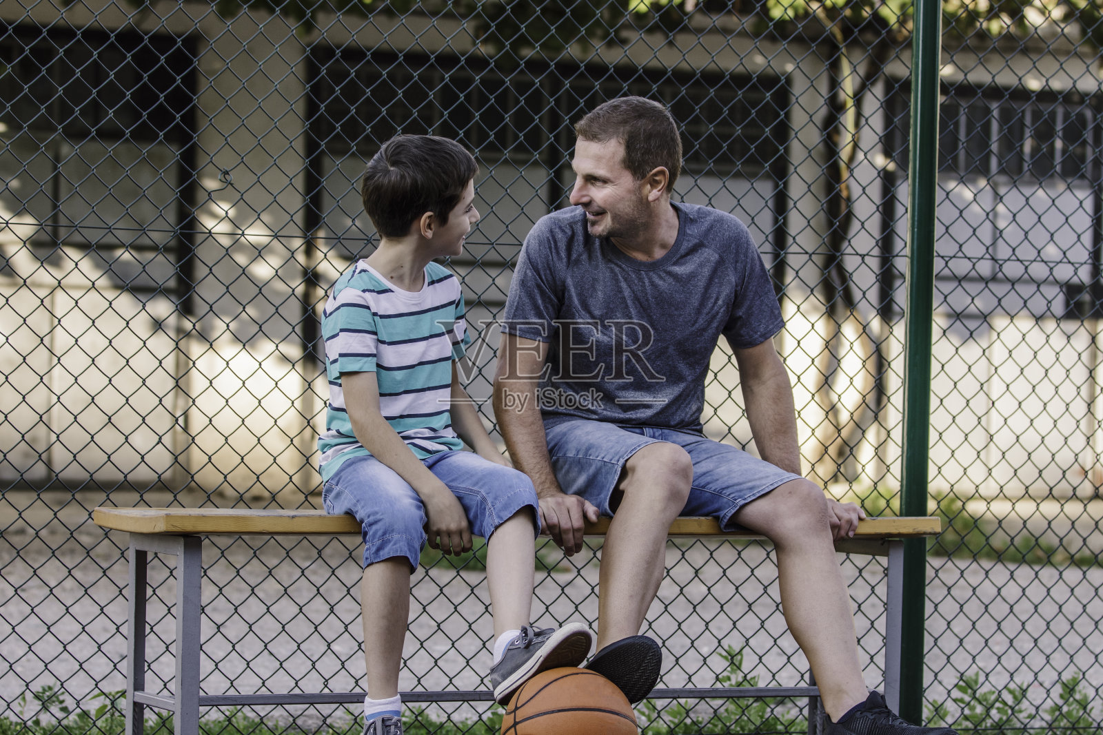 上午的训练。父子打篮球。父亲和儿子之间的对话照片摄影图片