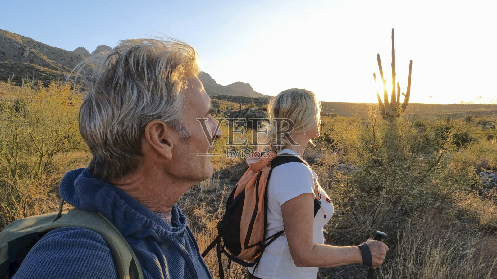 成熟的夫妇徒步穿越沙漠景观照片摄影图片