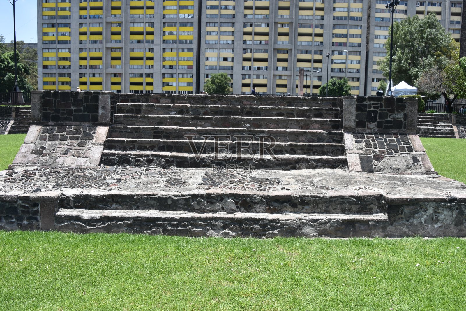 前景是阿兹特克平台，背景是现代公寓照片摄影图片